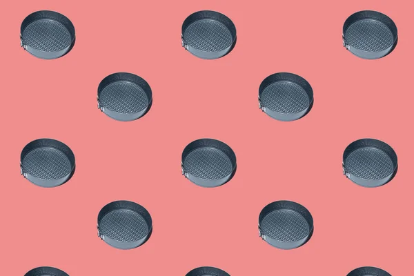 Seamless pattern of Round metal cake pan, tin for baking cakes and cookies. Black collapsible stainless steel round cooking empty pan for cupcakes on peach background.