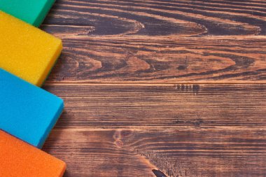 Mutfak temizliği koyu kırsal arka planda farklı renkleri süngerler. Tasarım için telif alanı olan üst görünüm