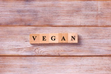 Vegan kelimesi beyaz tahta arka planda küplere yazılmış. Sağlıklı vejetaryen beslenme konsepti