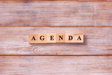 Tahta blokta yazan AGENDA kelimesi. Konu gündem iş konsepti listesi.