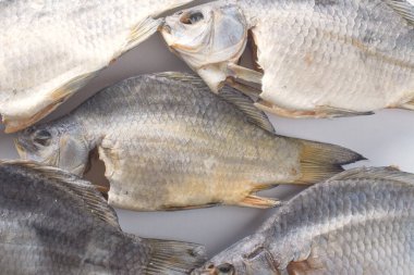 Beyaz arka planda kurumuş nehir balığı. Tuzlu bira mezesi. Kurutulmuş sazan balığı ve tuz.