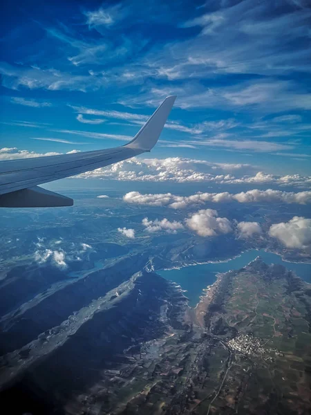 青空の下でスペインの貯水池の上を飛ぶボーイング737飛行機と背景に雲と — ストック写真