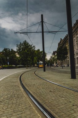 Parlamento yakınlarındaki Budapeşte caddesinde raylar boyunca uzanan sarı tramvay