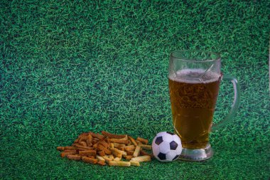 bira ile bira bardağı, kraker, yeşil çim bir arka plan üzerinde futbol topu