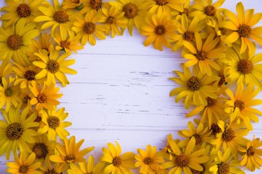 Ahşap ışıklı arka planda sarı çiçekler. Sarı çiçekleri andırıyor.