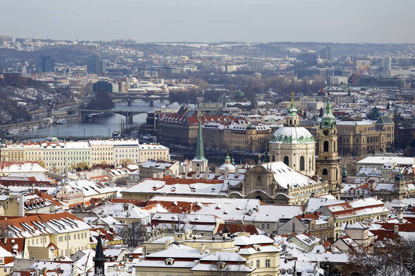Snowy Prague City with St. Nicholas' Cathedral from Hill Petrin in the sunny Day, Czech republic