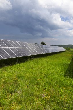 Bahar çiçekli çayırdaki güneş enerjisi santrali 