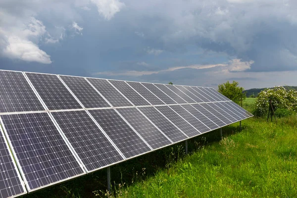 Bahar Çiçekli Çayırdaki Güneş Enerjisi Santrali — Stok fotoğraf