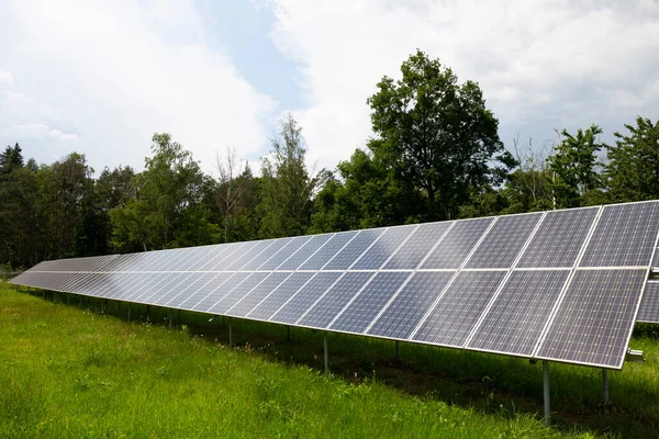 Bahar Çiçekli Çayırdaki Güneş Enerjisi Santrali — Stok fotoğraf