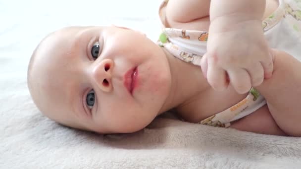 Lindo Bebê Está Deitado Cama Olhando Para Câmera — Vídeo de Stock