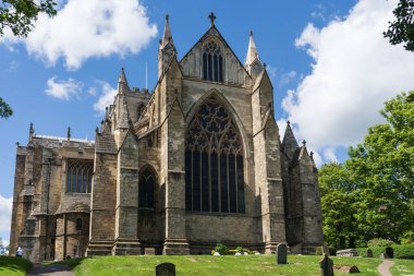 Ripon Katedrali 'nin doğu ucunda antik kuleler ve ön planda bir mezarlık, Ripon, Kuzey Yorkshire, İngiltere.