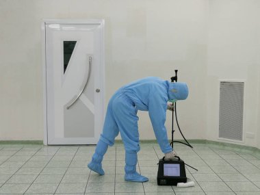 Müfettiş Parçacık Sayacı ile ameliyathane içinde toz test ediyor.