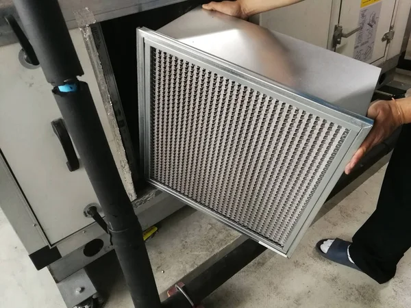 Yumuşak Odaklanma İnsanda Hava Elleme Birimi Filtresi, Teknisyen, yeni bir filtre - HVAC bakım - değiştirmek için orta filtreli hava tutma ünitesini kontrol ediyor