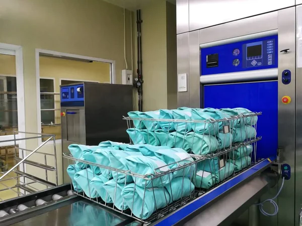 Sterilizasyondan alınan cerrahi elbiseye sterilizatörle odaklanın.