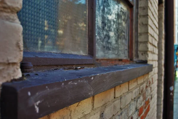 在一座废弃的建筑物上 关上了一个脏兮兮的破碎的窗台上的窗台 — 图库照片
