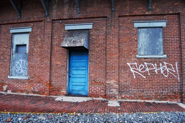 废弃的带有铁轨和涂鸦的砖造火车站 — 图库照片