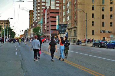 Bir sokak ortasında yürüyen protestocular