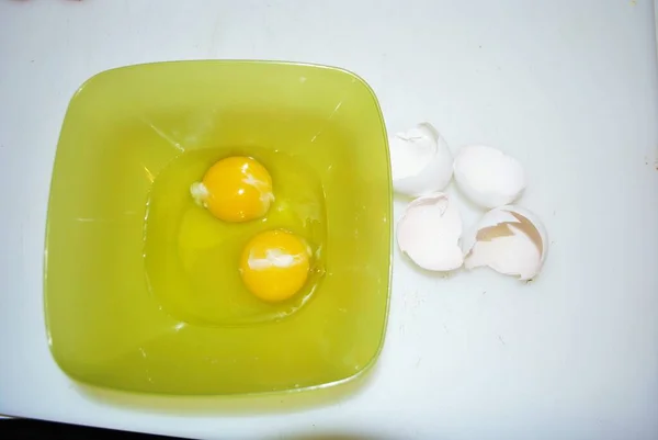 Close Dois Ovos Crus Uma Tigela Plástico Verde Cascas Ovos — Fotografia de Stock