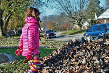 Yaprak yığınında oynayan genç bir kız
