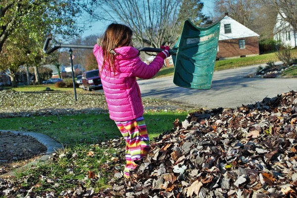 Yaprak yığınında oynayan genç bir kız