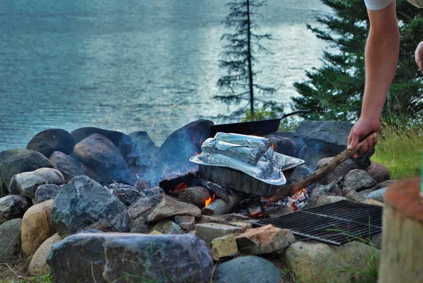 Cooking corn on a camp fire next to the lake