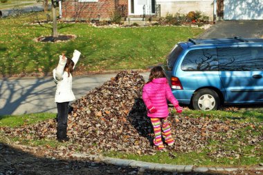 Yaprak yığınında oynayan genç bir kız