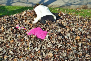 Yaprak yığınında oynayan genç bir kız