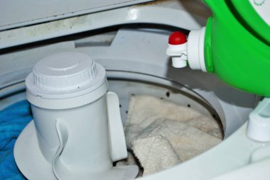 Çamaşır makinesinde çamaşır deterjanı dolu kirli havlular.