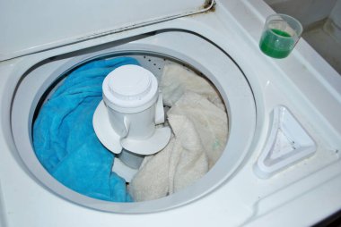 Çamaşır makinesinde çamaşır deterjanı dolu kirli havlular.