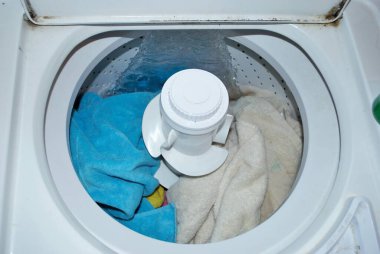 Suyla dolu bir çamaşır makinesinde kirli havlular.