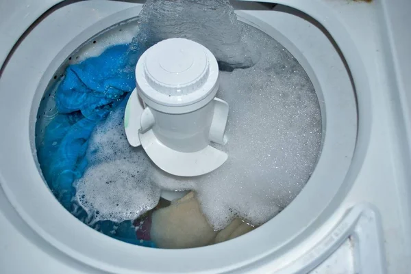 Suyla dolu bir çamaşır makinesinde kirli havlular.