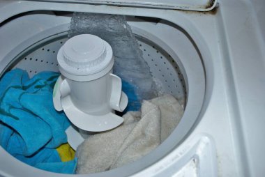 Suyla dolu bir çamaşır makinesinde kirli havlular.