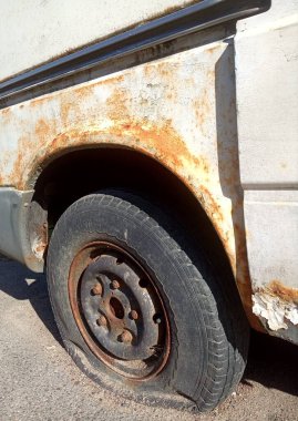 Patlak lastik ve paslı araba, eski araba parçaları.