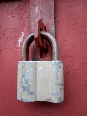 Metal bir kapının üzerinde eski paslı bir kilit.