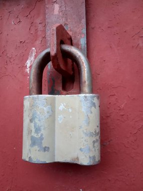 Metal bir kapının üzerinde eski paslı bir kilit.