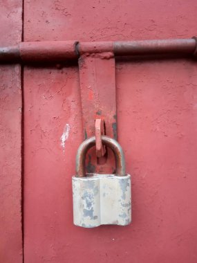 Metal bir kapının üzerinde eski paslı bir kilit.