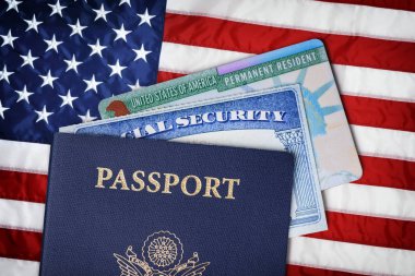 Amerika Birleşik Devletleri pasaport, sosyal güvenlik kartı ve Amerikan bayrağı üzerinde ikamet kartı. Göç kavramı 