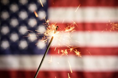 Arka Planda Amerikan Bayrağı ile Sparkler Closeup. 4 Temmuz Bağımsızlık Günü Kutlanması
