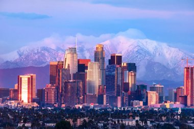 Şehir Los Angeles siluetinin arkasında karla kaplı dağlar