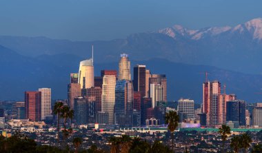 Şehir Los Angeles siluetinin arkasında karla kaplı dağlar
