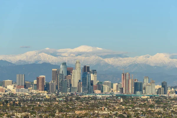 Centro de Los Ángeles skyline con montañas cubiertas de nieve detrás de un —  Fotos de Stock