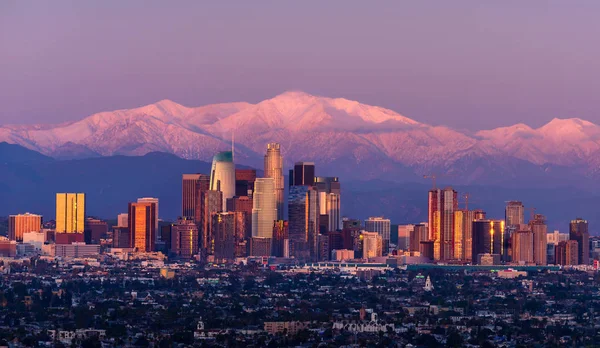 Centro de Los Ángeles skyline con montañas cubiertas de nieve detrás de un — Foto de Stock