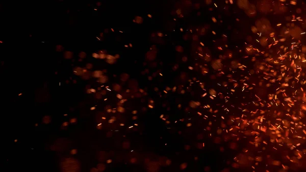 Gece gökyüzündeki büyük ateşten yanan kırmızı kıvılcımlar uçuşuyor. Ateş, ışık ve yaşam teması üzerine çok soyut bir arka plan. Yanan közler siyah arkaplan üzerinde uçan parçacıklar.