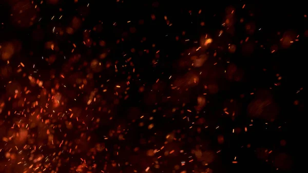 Gece gökyüzündeki büyük ateşten yanan kırmızı kıvılcımlar uçuşuyor. Ateş, ışık ve yaşam teması üzerine çok soyut bir arka plan. Yanan közler siyah arkaplan üzerinde uçan parçacıklar.