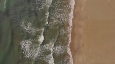 Okyanus dalgaları. Havadan görünüm dalgaları beyaz kumlu plajda kırılır. Güzel plajda deniz dalgaları havadan görünümü drone 4k atış.