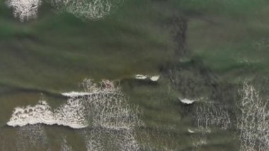 Okyanus dalgaları. Havadan görünüm dalgaları beyaz kumlu plajda kırılır. Güzel plajda deniz dalgaları havadan görünümü drone 4k atış.