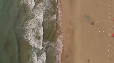 Okyanus dalgaları. Havadan görünüm dalgaları beyaz kumlu plajda kırılır. Güzel plajda deniz dalgaları havadan görünümü drone 4k atış.
