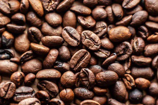 Roasted brown coffee beans, can be used as a background and texture. Coffee beans on the table background texture. Background full of coffe beans studio shoot.