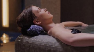 Vücut bakımı kavramı. Güzellik ve vücut bakımı. Girdap banyosundan hoşlanan genç bir kadın görüntüsü. Spa jakuzisinde dinlenen şehvetli genç bir kadın..