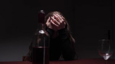 Depresyonda olan genç ve güzel bir kadın, alkol içiyor. Taciz ve alkolizm kavramı. Şişesi ve şarabı olan alkolik bir kadın.. 